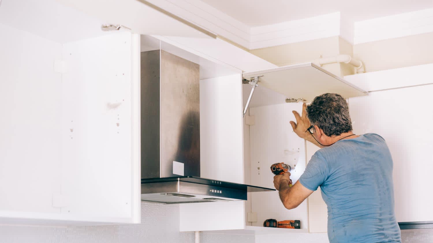 A man installing kitchen cabinets
