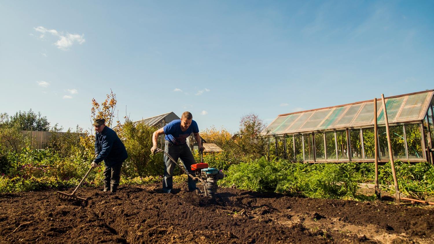 Two men tilling the garden’s soil
