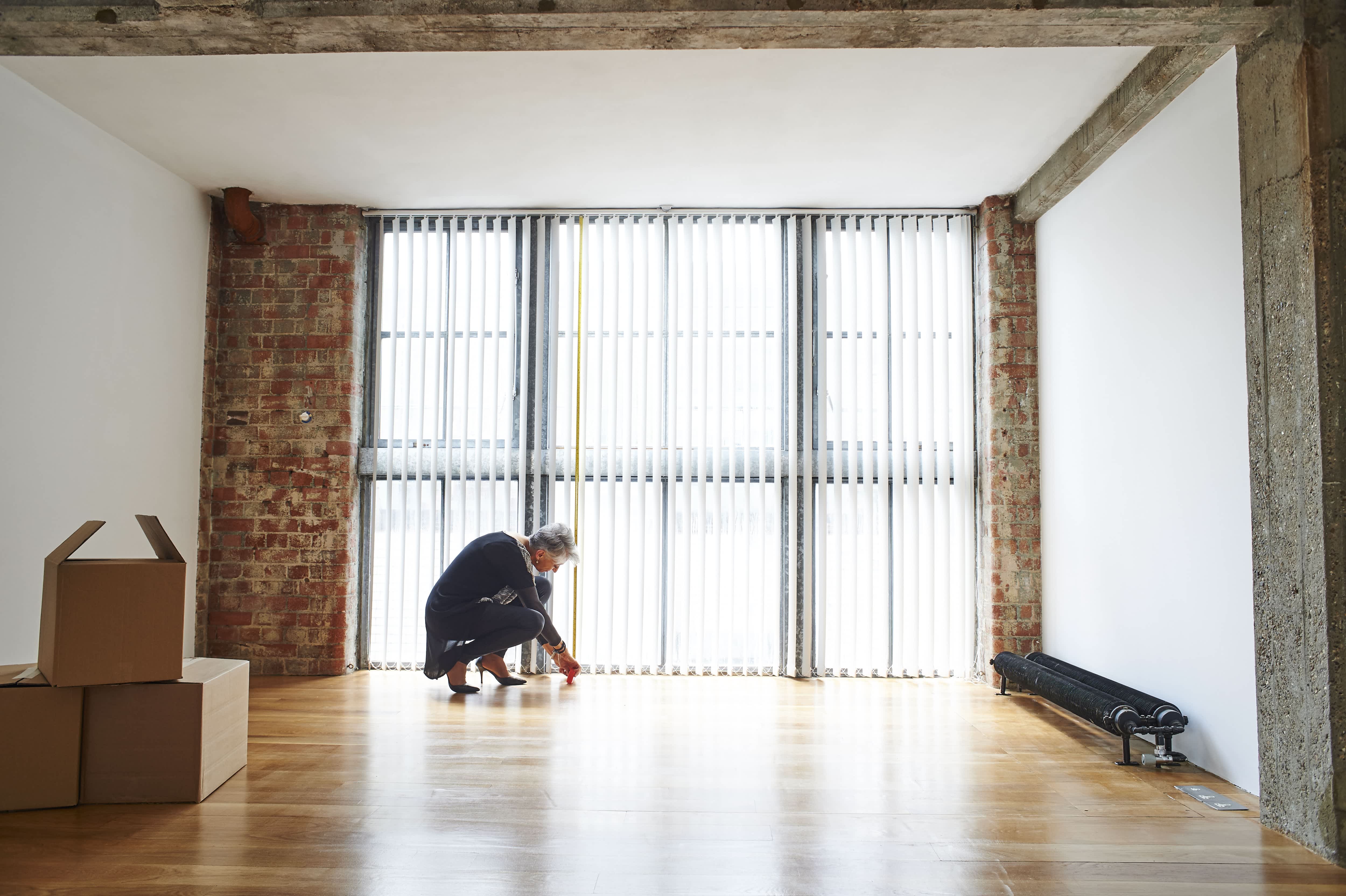 Woman measuring the square footage of a room