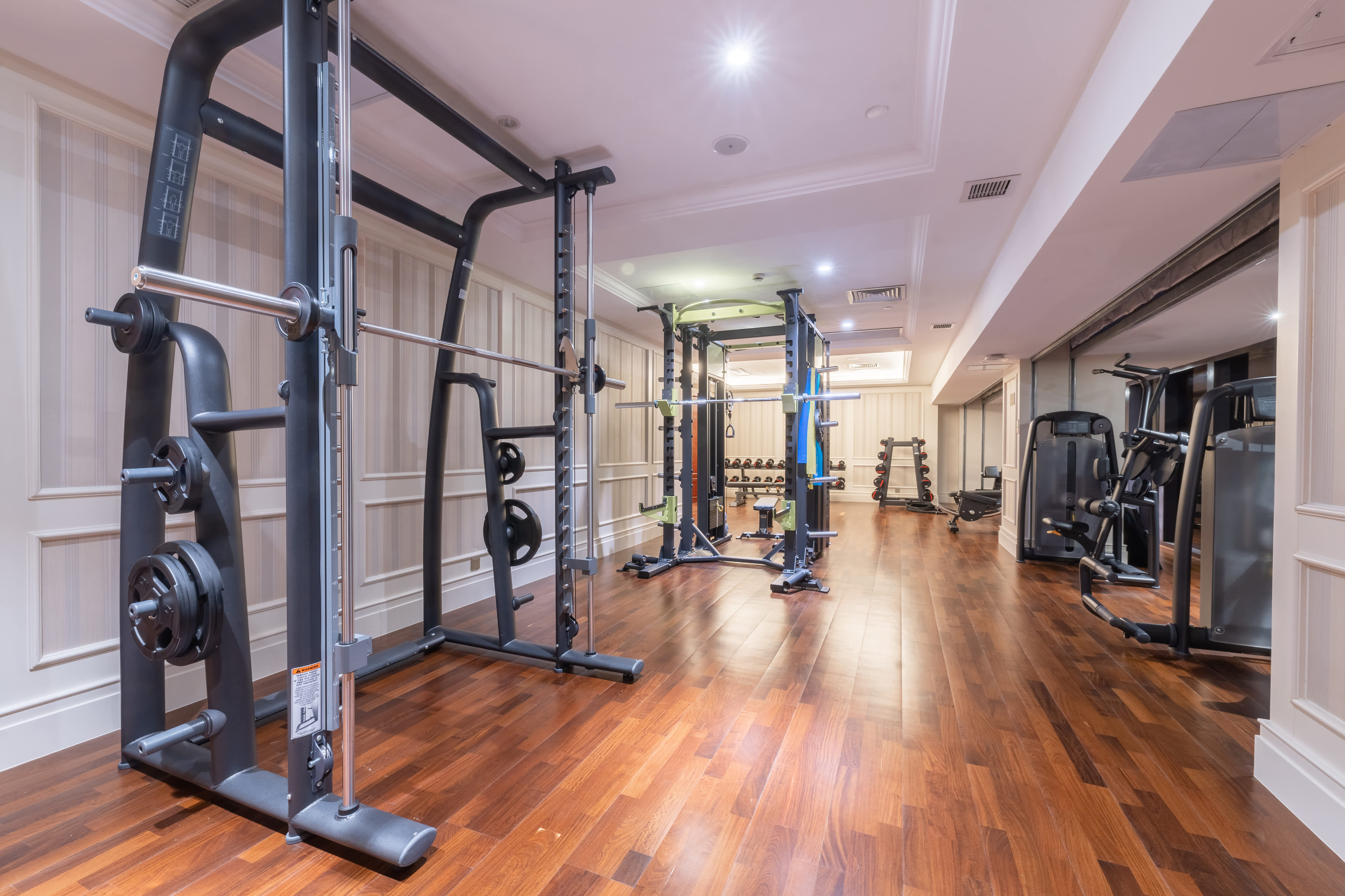 Basement home gym with a wood floor and weight lifting equipment
