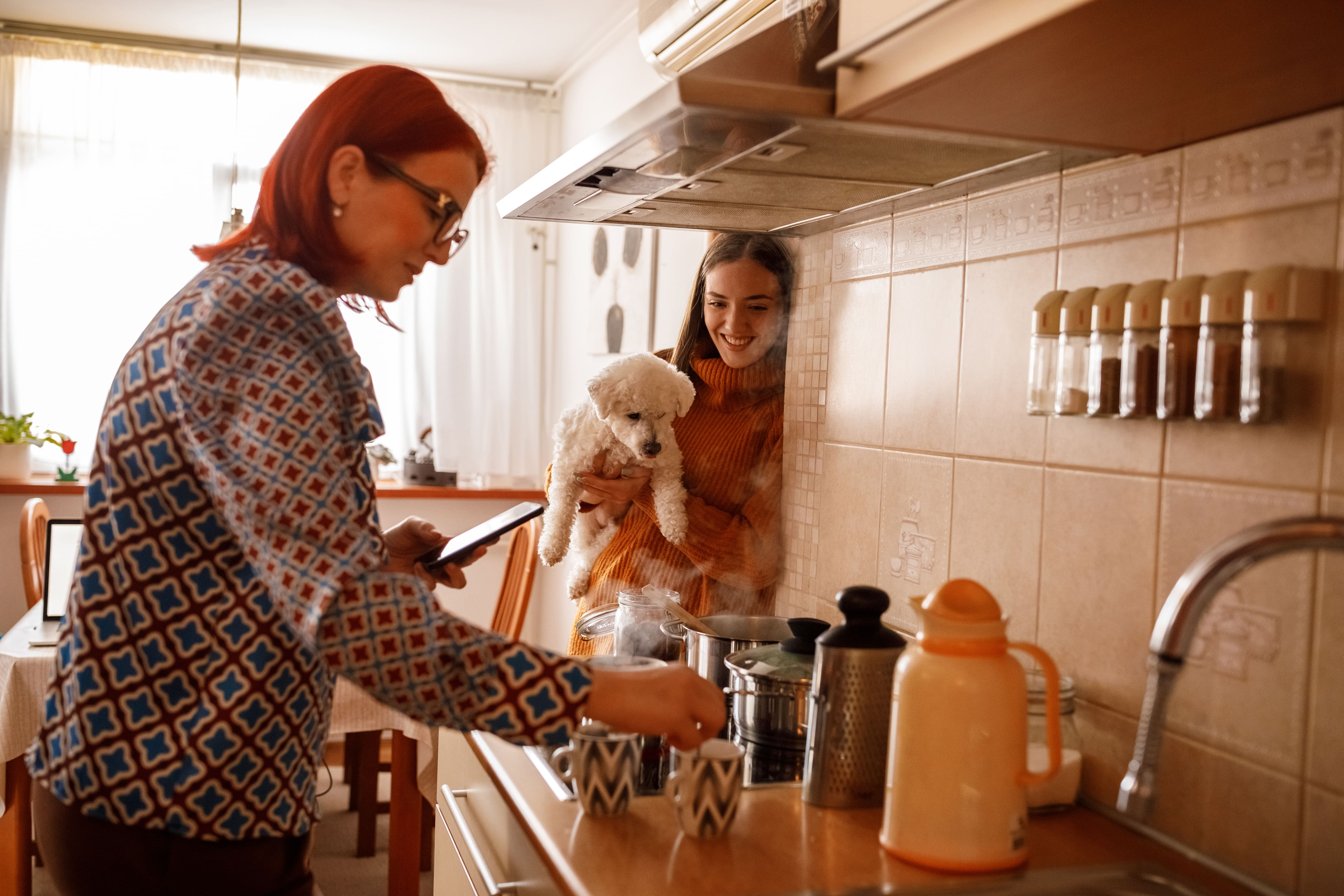 Mother and daughter making coffee in an apartment