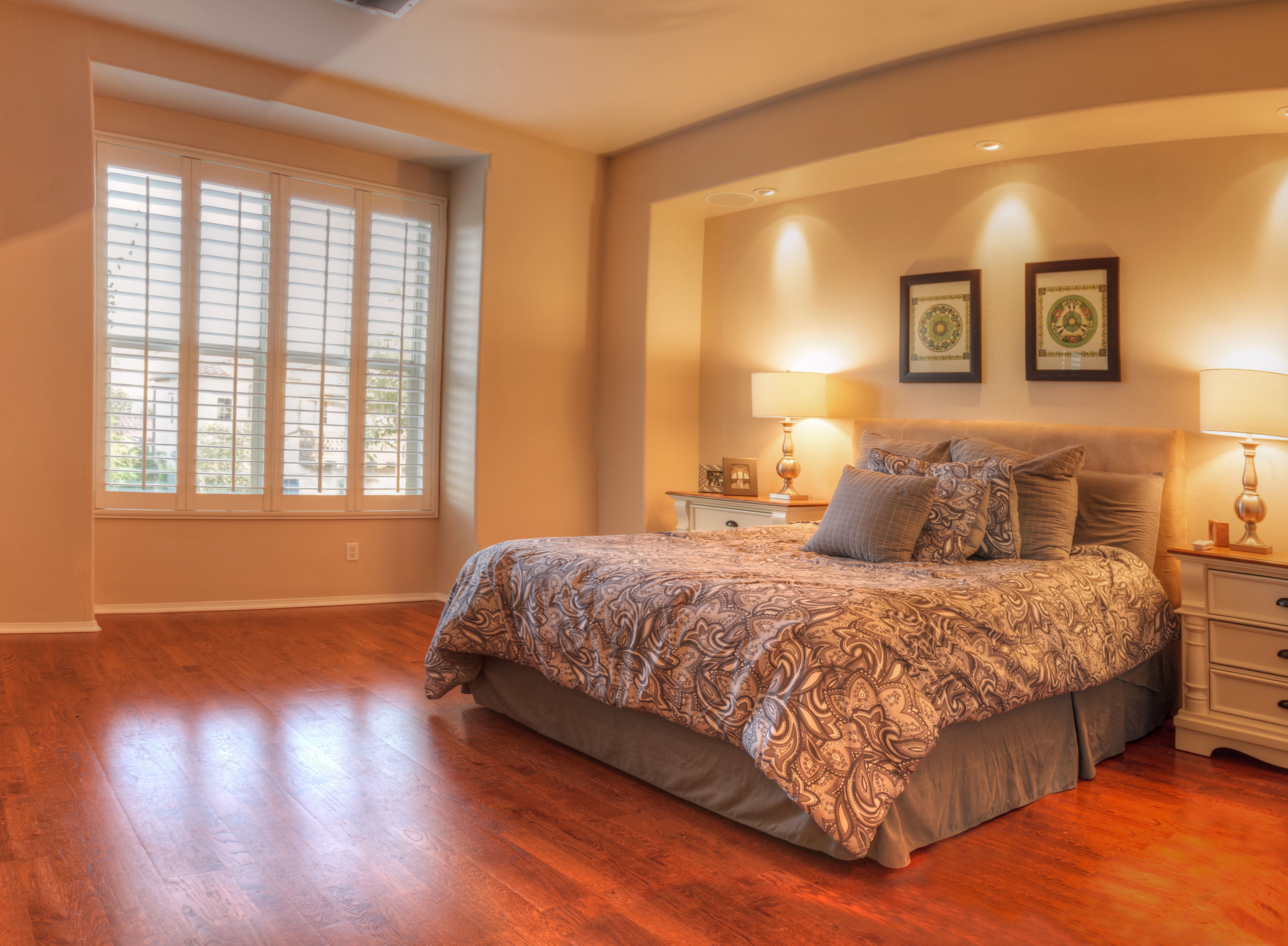 A tan bedroom with recessed lights