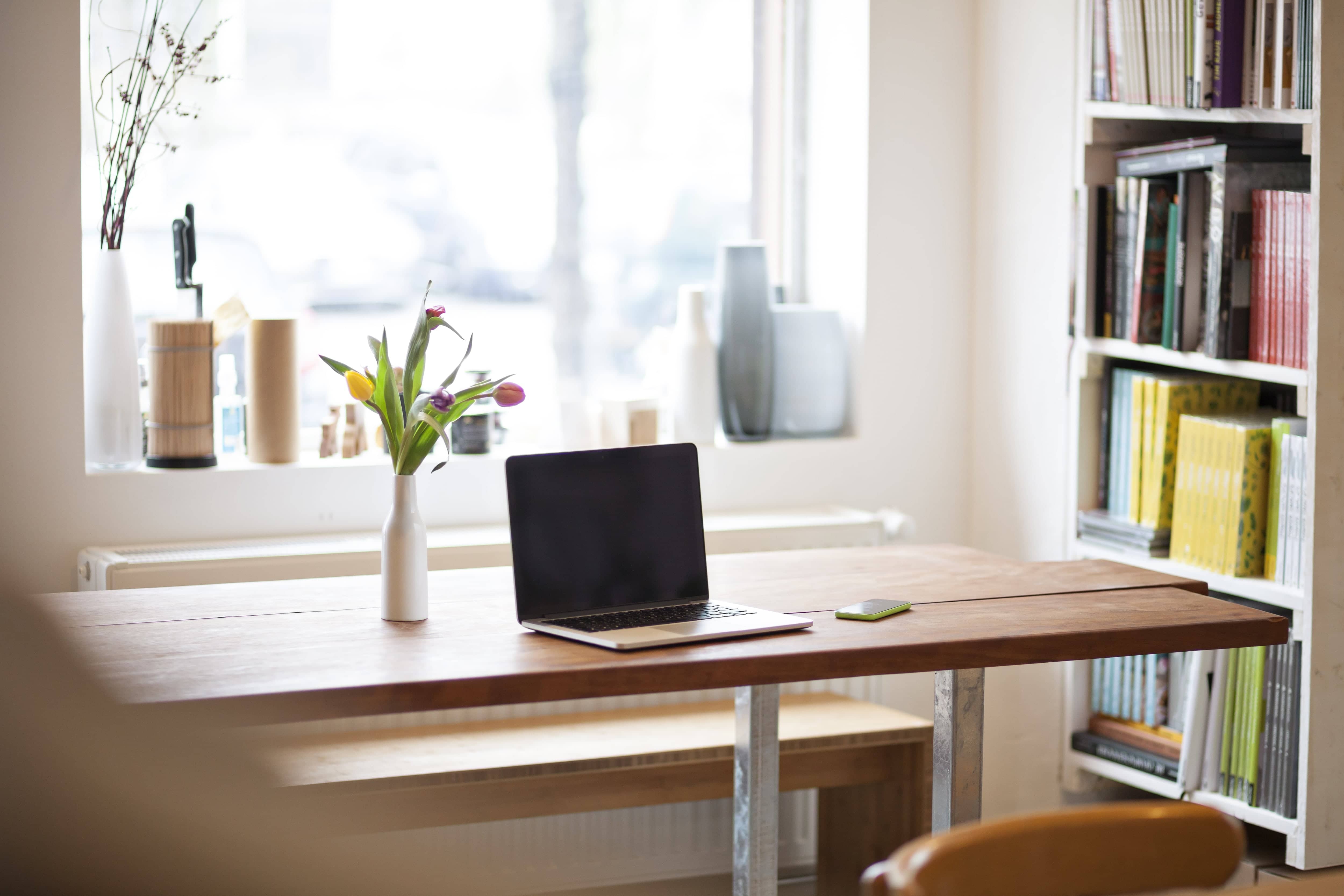 Table in dining area of apartment with laptop on top
