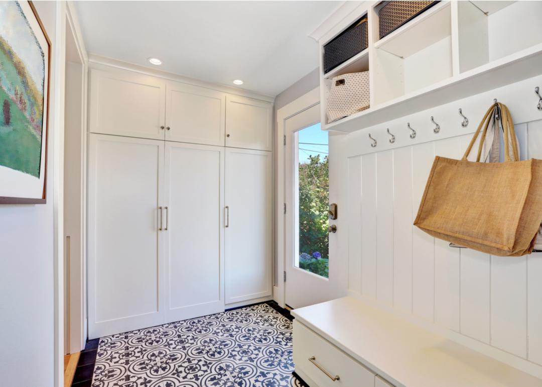 An entryway with cabinets and wall hooks
