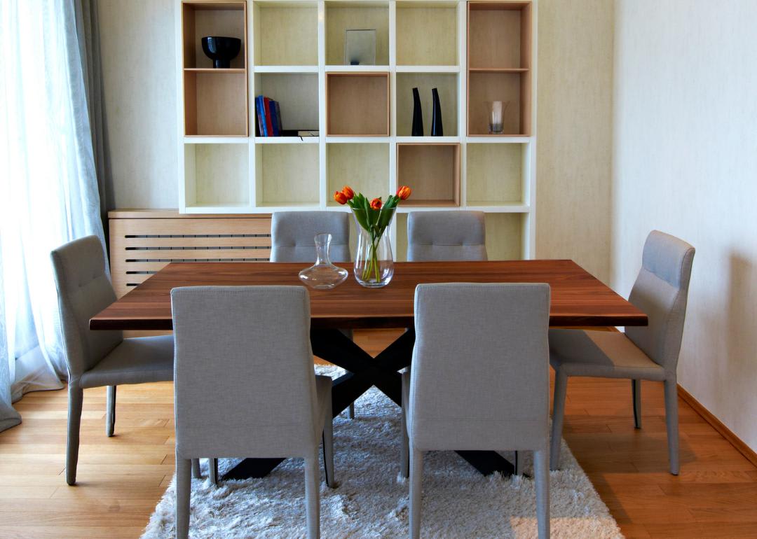 A dining table with six upholstered chairs