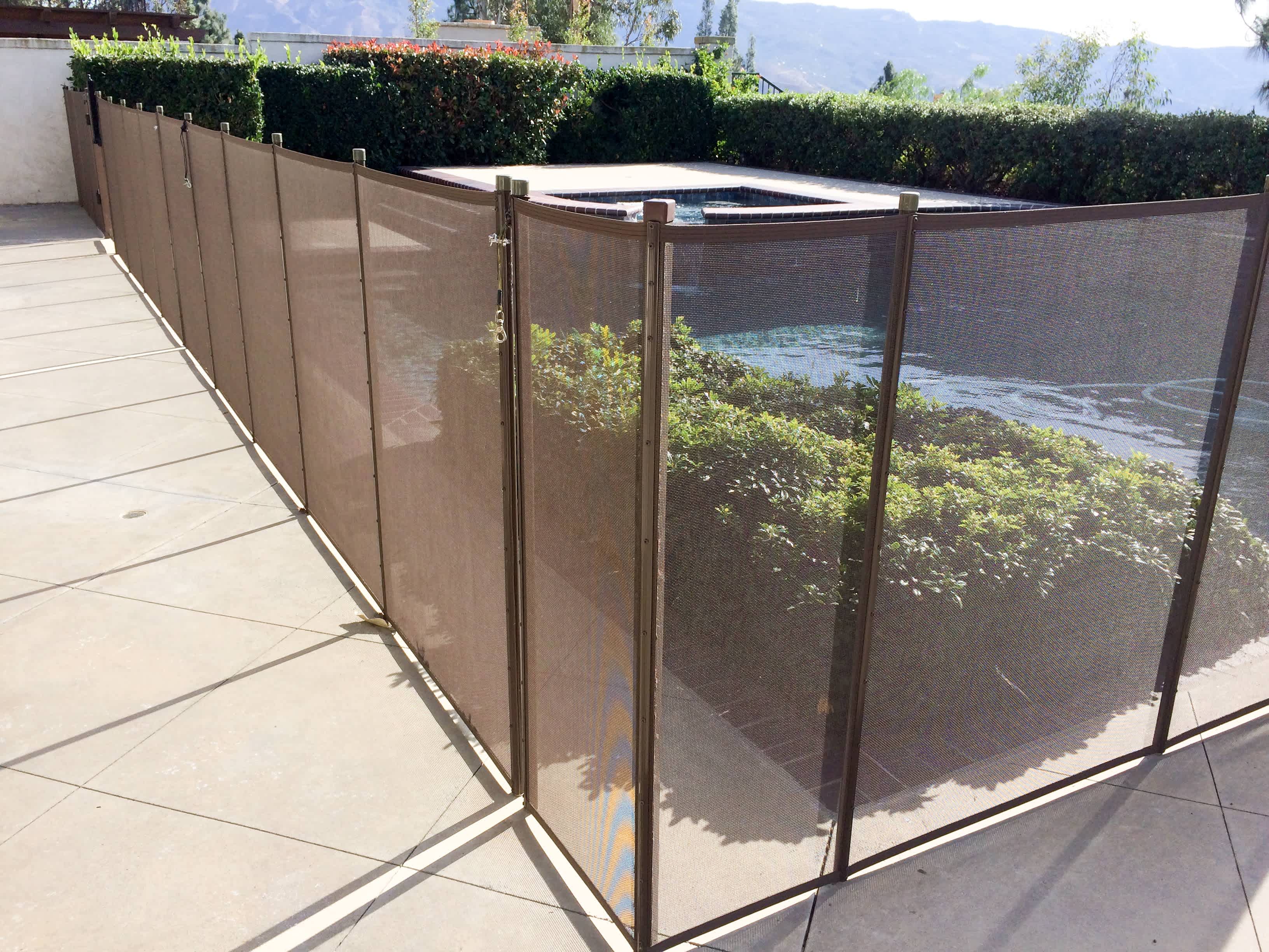A mesh wall fence around an inground pool