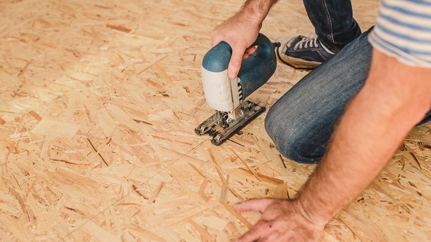 man installing plywood flooring