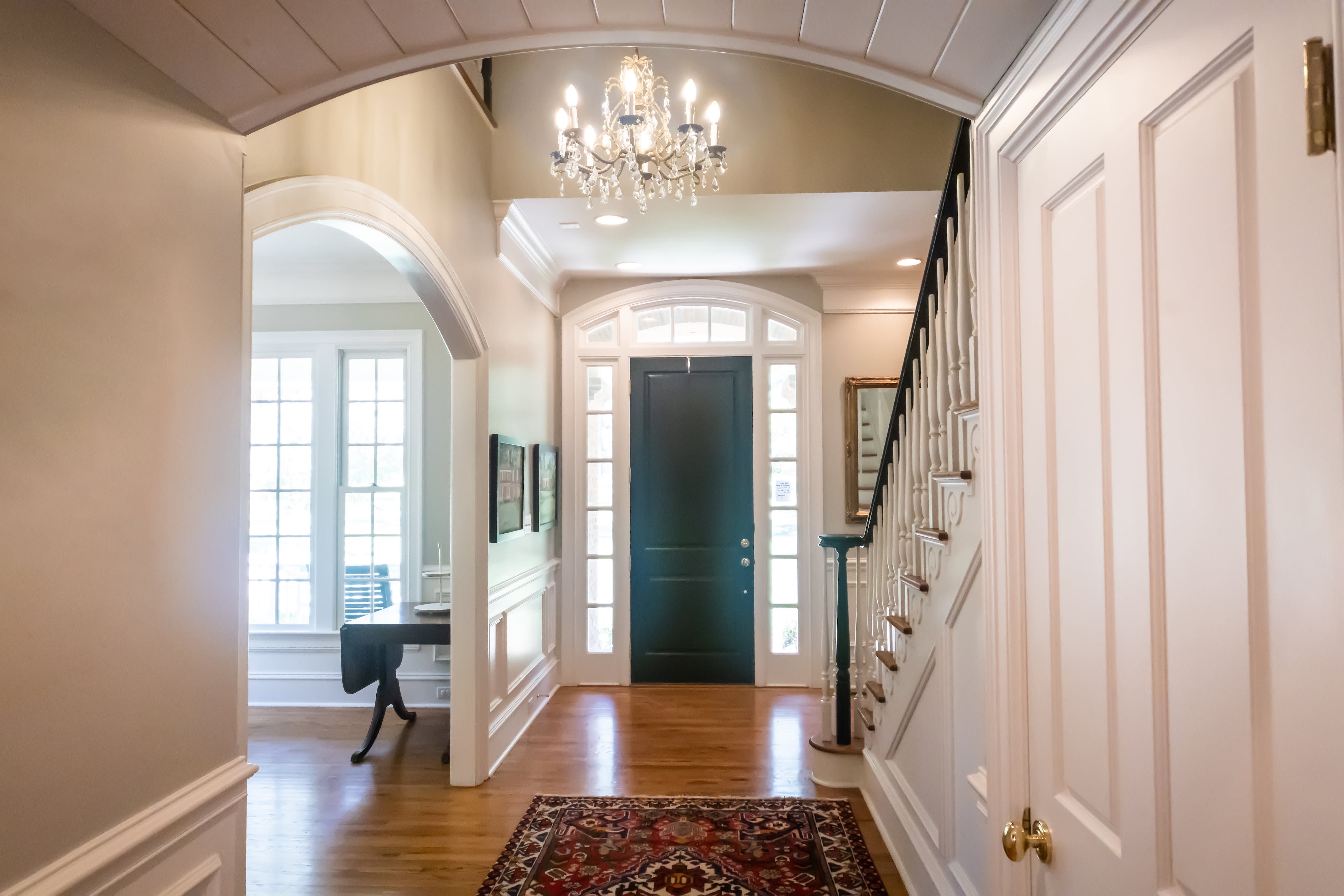 An upscale front entryway with a crystal chandelier