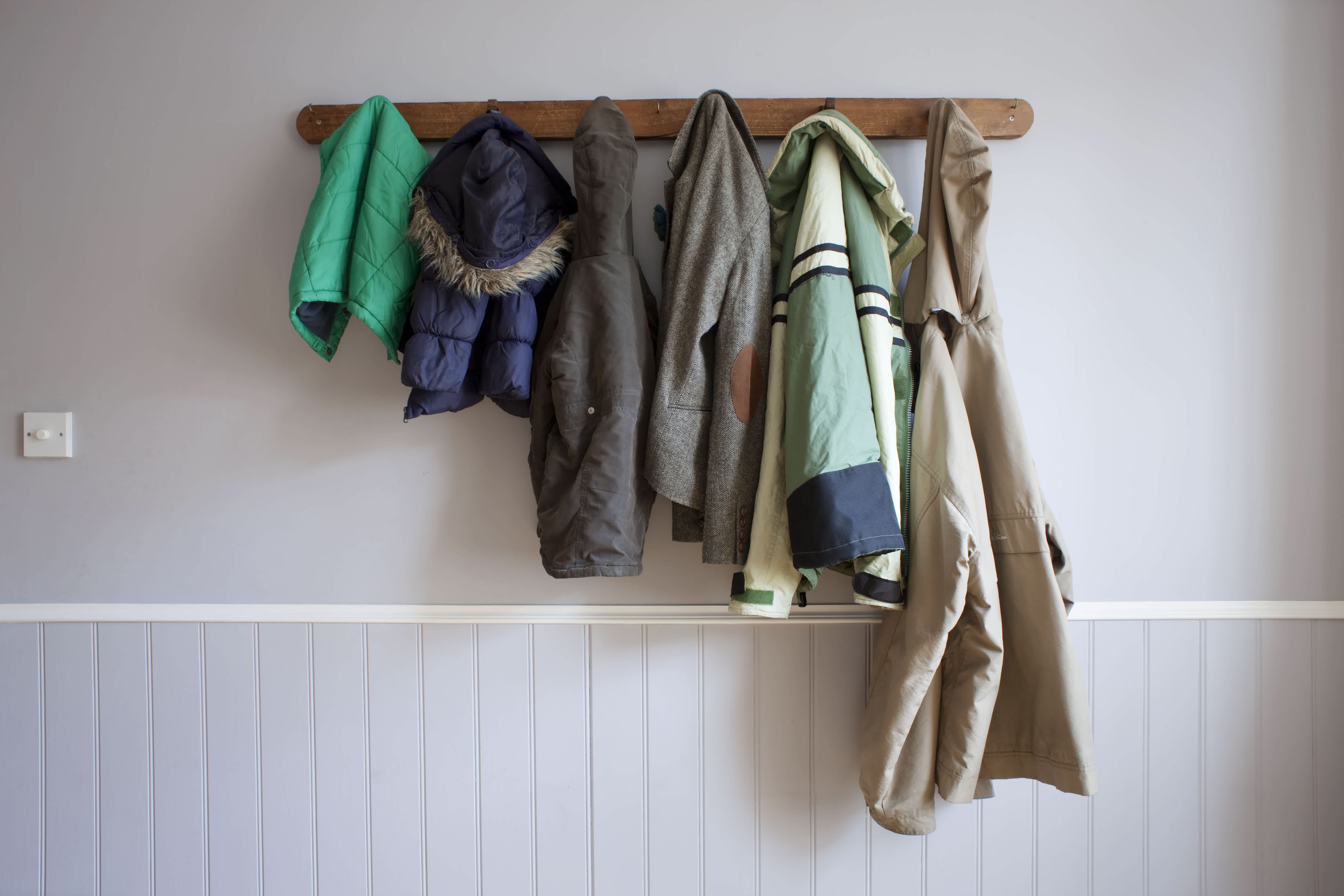 Coats hanging on a wooden wall coat rack