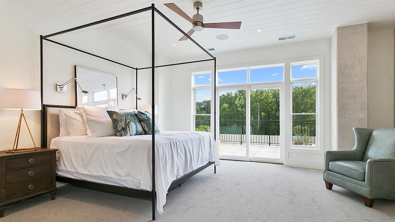 A carpeted bedroom with a large canopy bed