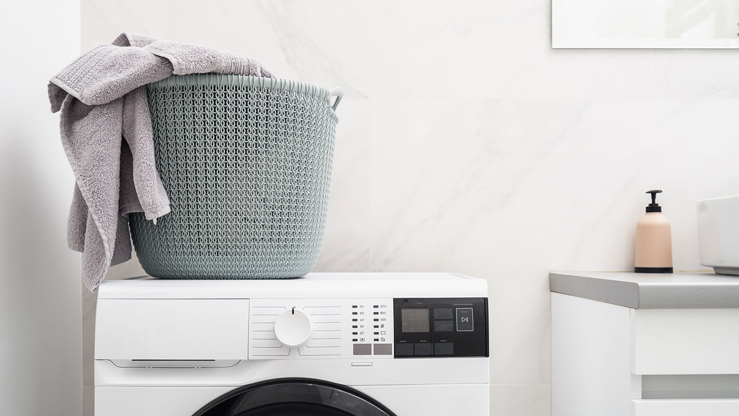 Laundry basket with towels on top of washing machine