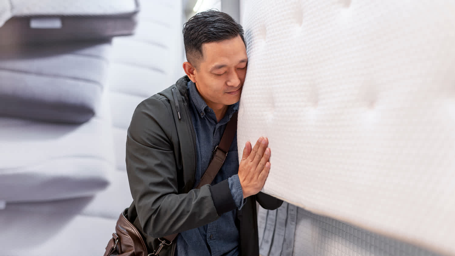 A man testing a mattress’ firmness