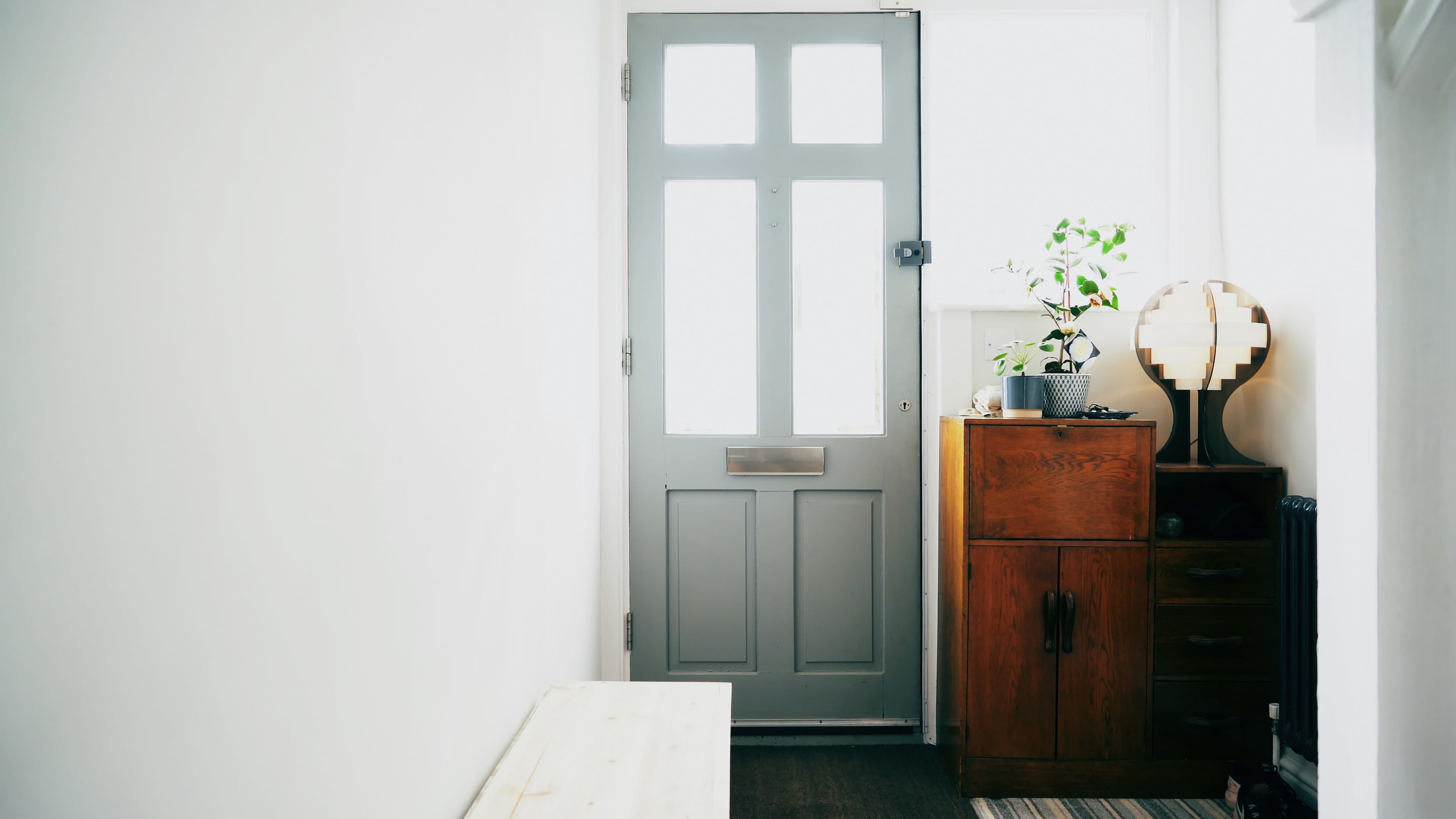 A bright home entryway with decor sitting on repurposed side tables