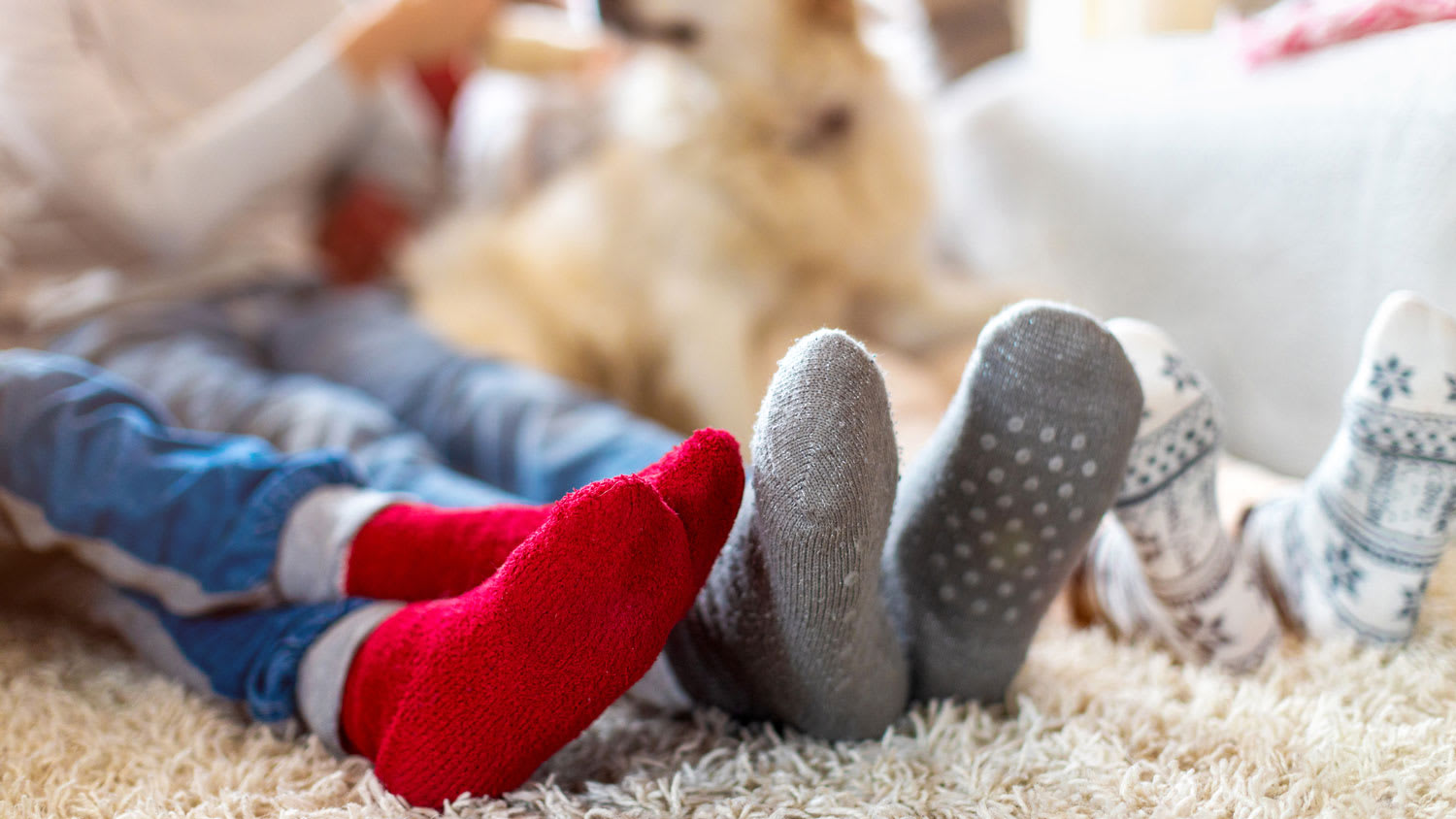 A family wearing socks lying on a carpet