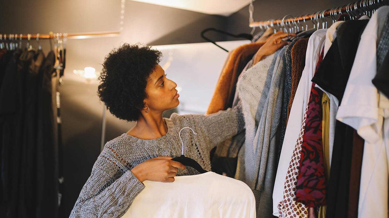 woman picking out clothes from closet