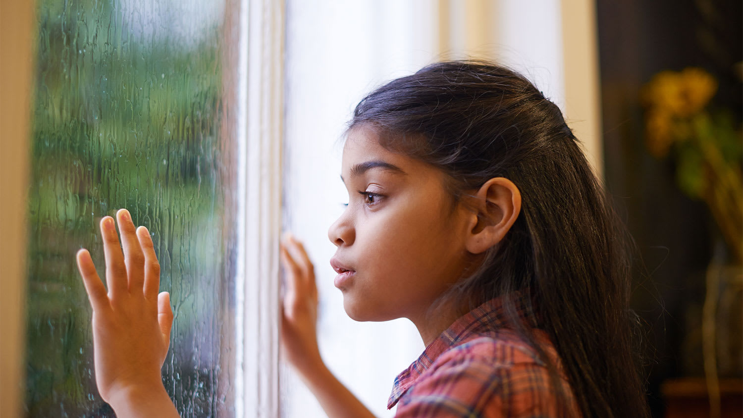 Girl looking out window at storm