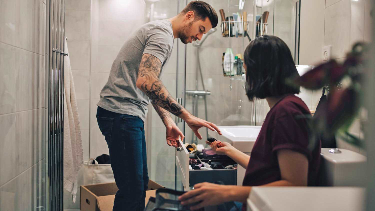 couple boxing up items in bathroom