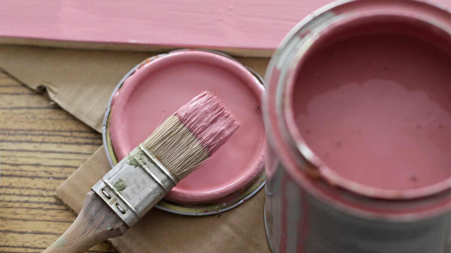 open can of pink paint and paint brush