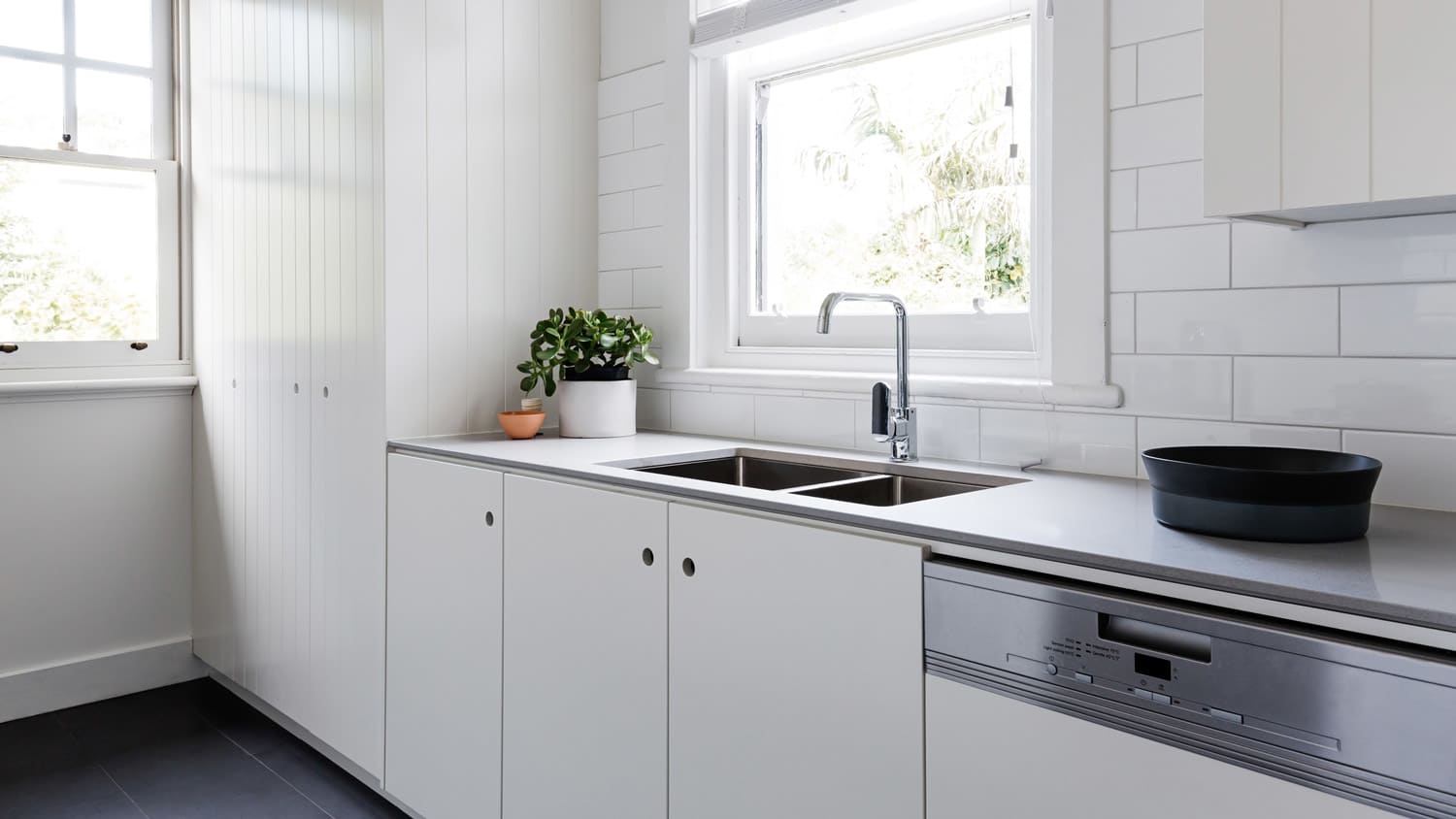A minimalistic with charcoal laminate countertops and white cabinets