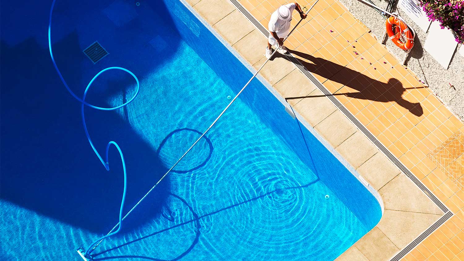 A man cleans a swimming pool