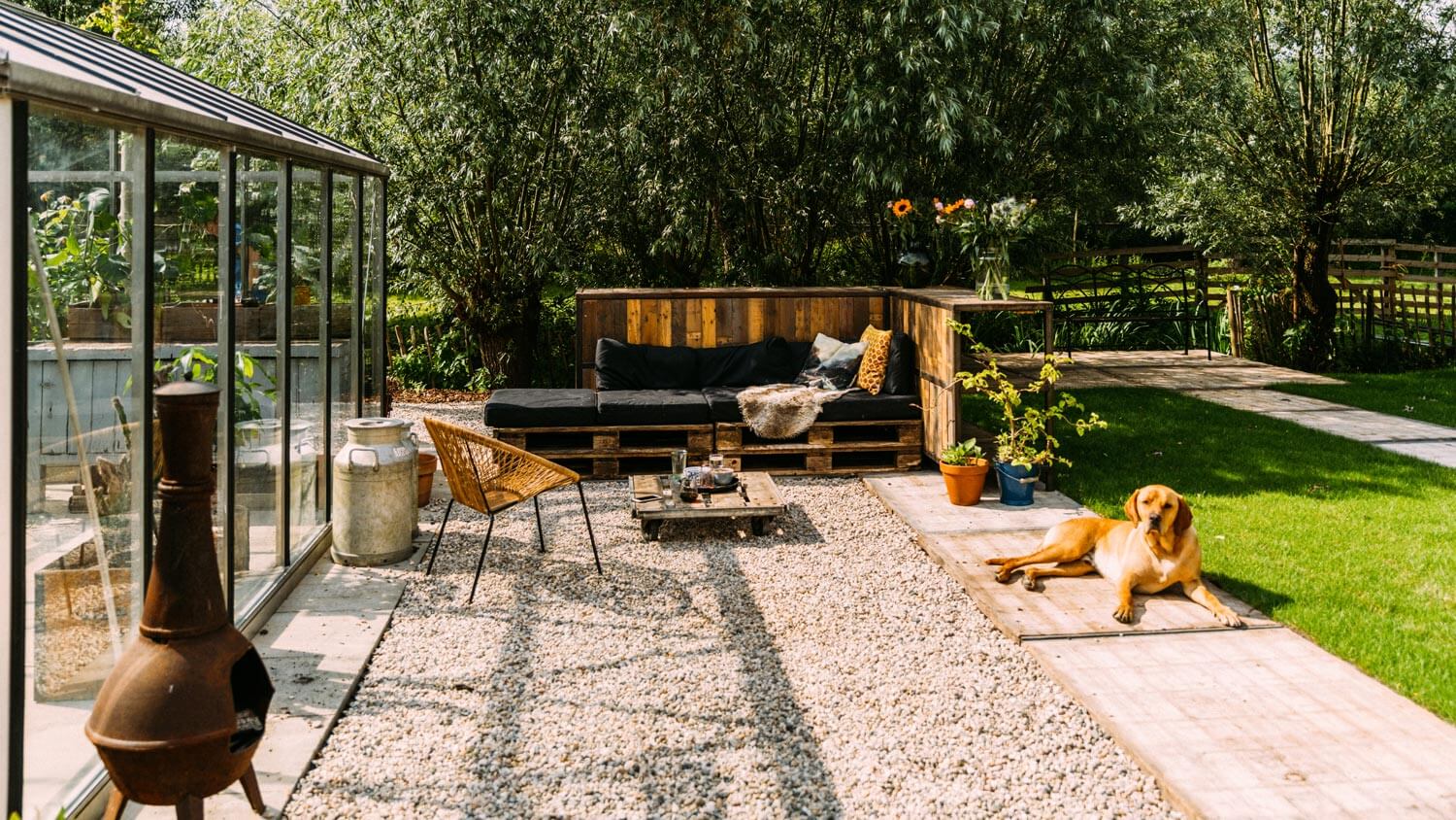A patio with a relaxing dog and decomposed granite laid on the ground