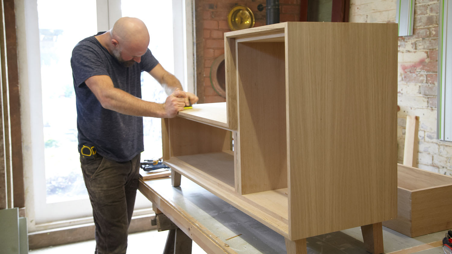 A carpenter building a MDF cupboard