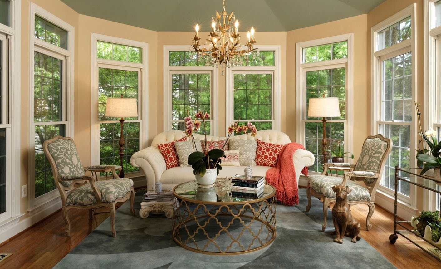 view of bright sunroom with windows on all sides and patio furniture