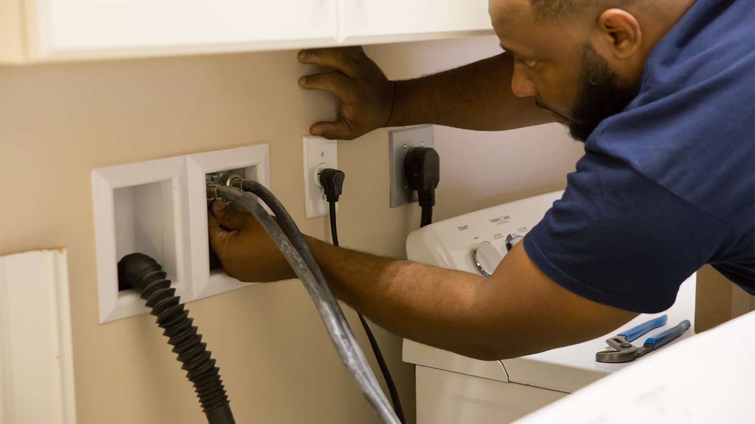 Man installing washer hose