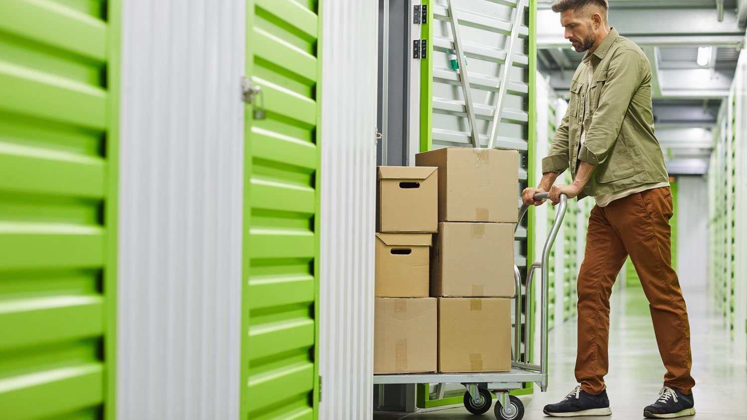 A man pushing a trolley in a self storage unit