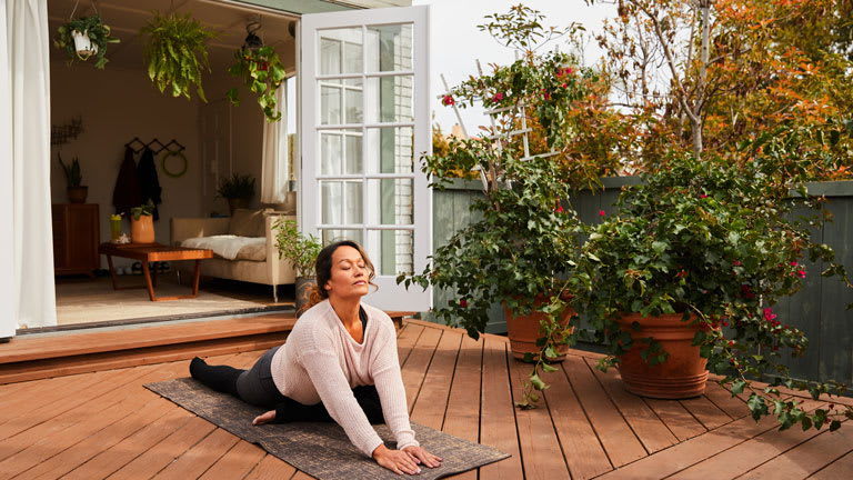 woman practicing yoga with her eyes closed on her patio