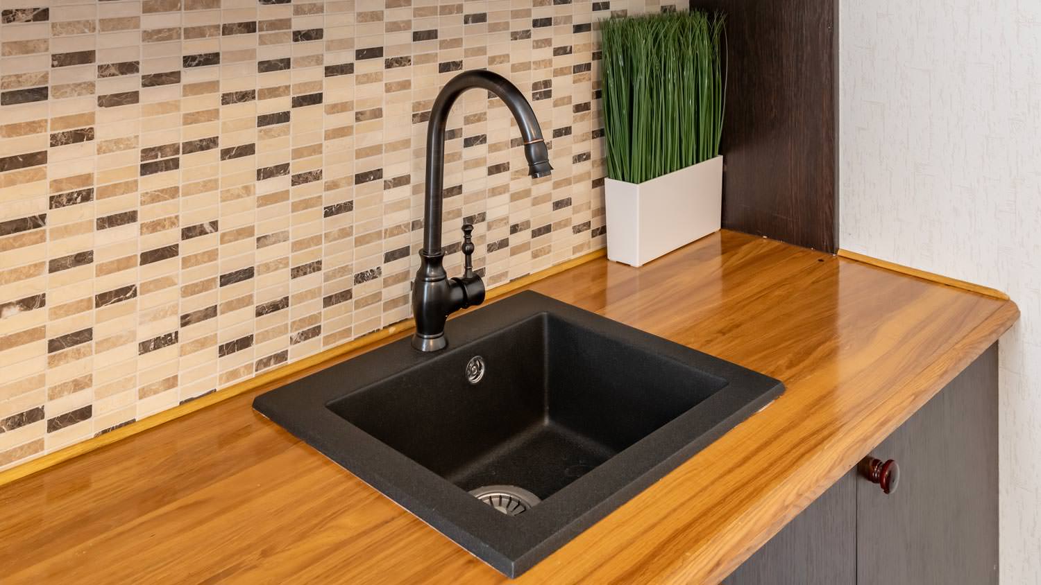 Small black square single basin sink in wet bar
