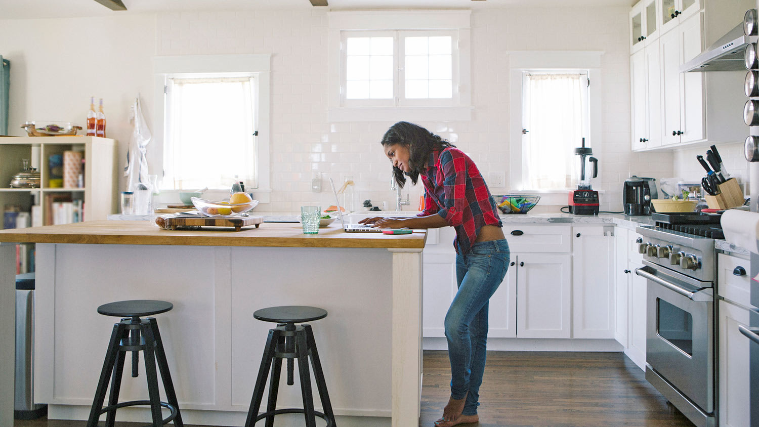 Woman on laptop at kitchen island