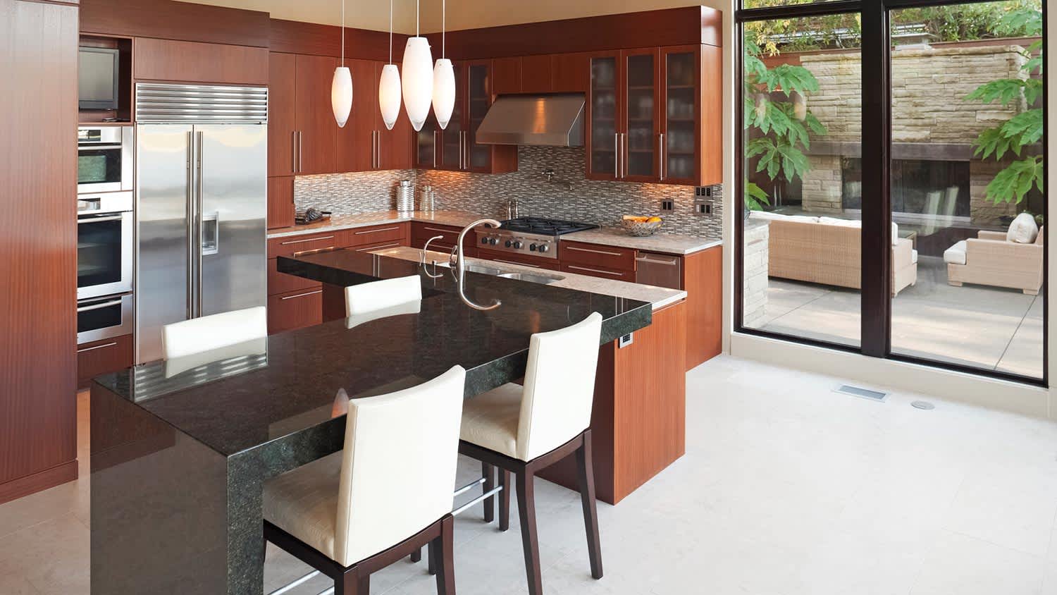 White and stainless steel kitchen with barstools at island