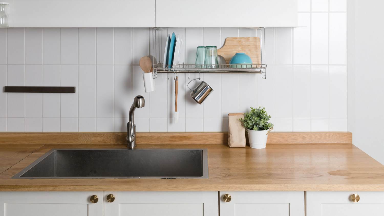A modern dark gray deep sink in a tidy kitchen