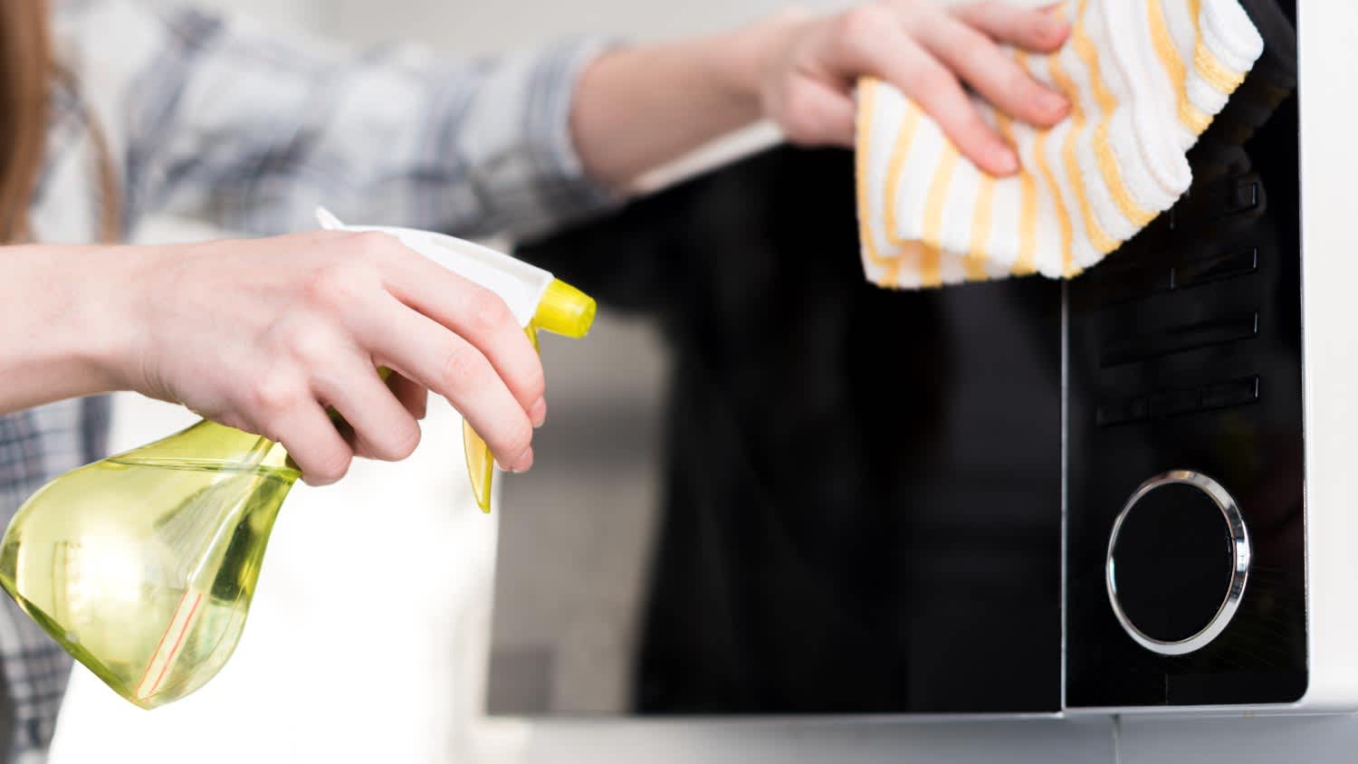 A woman cleaning microwave