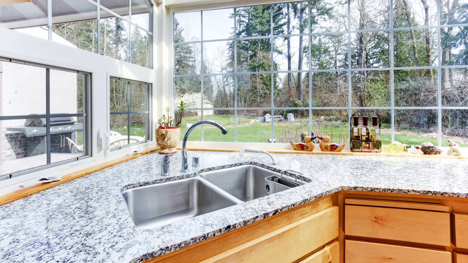 A kitchen corner sink on a granite countertop