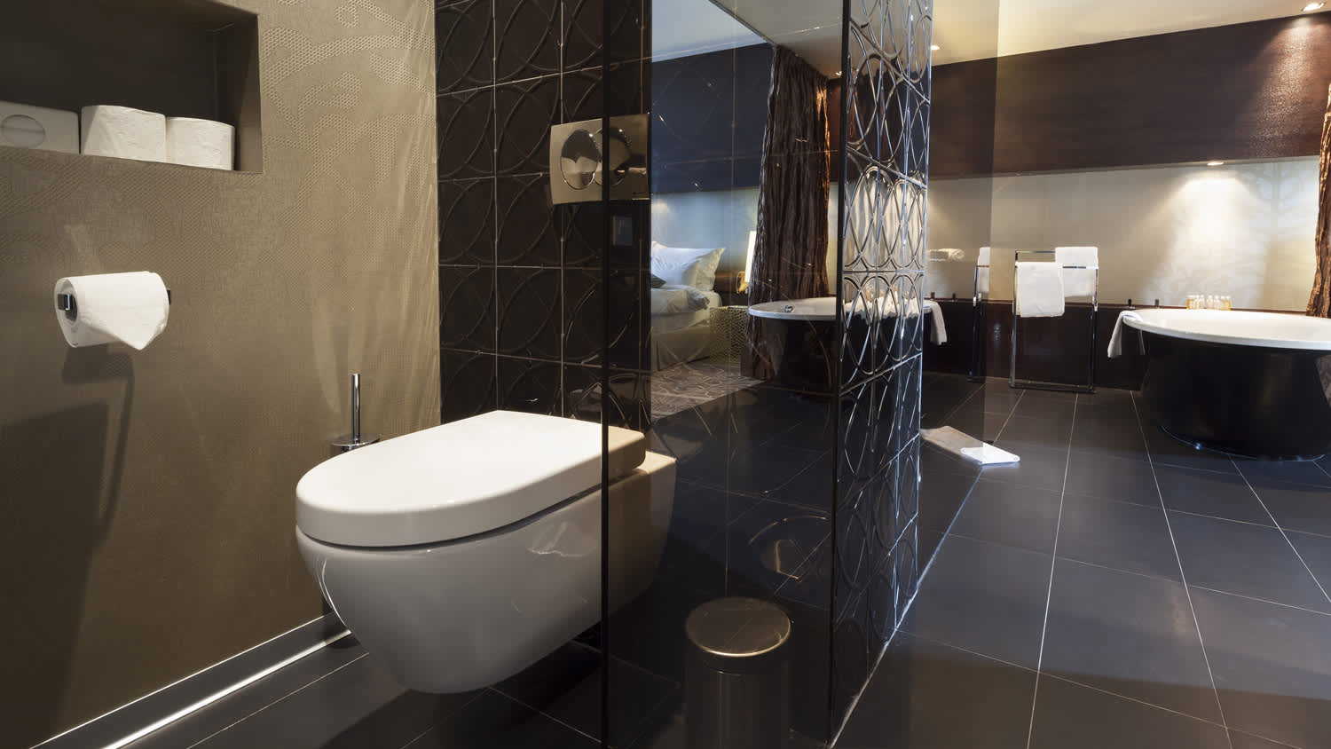 A modern toilet in black tiled bathroom