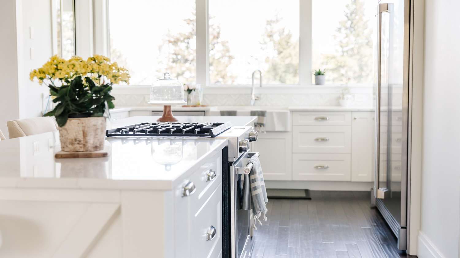 A spacious bright kitchen with yellow flowers on the kitchen island