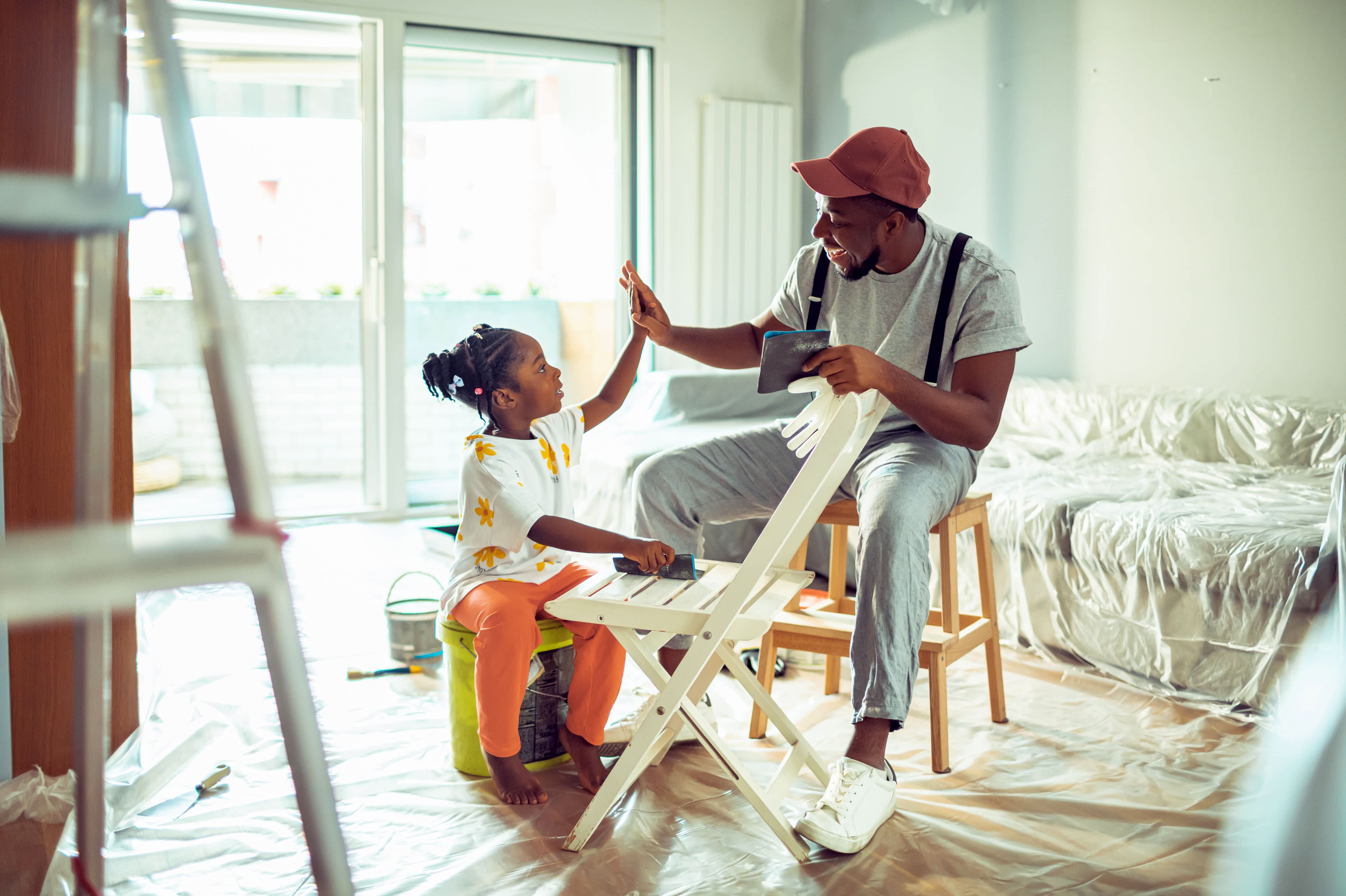 Father and daughter sanding a chair before painting