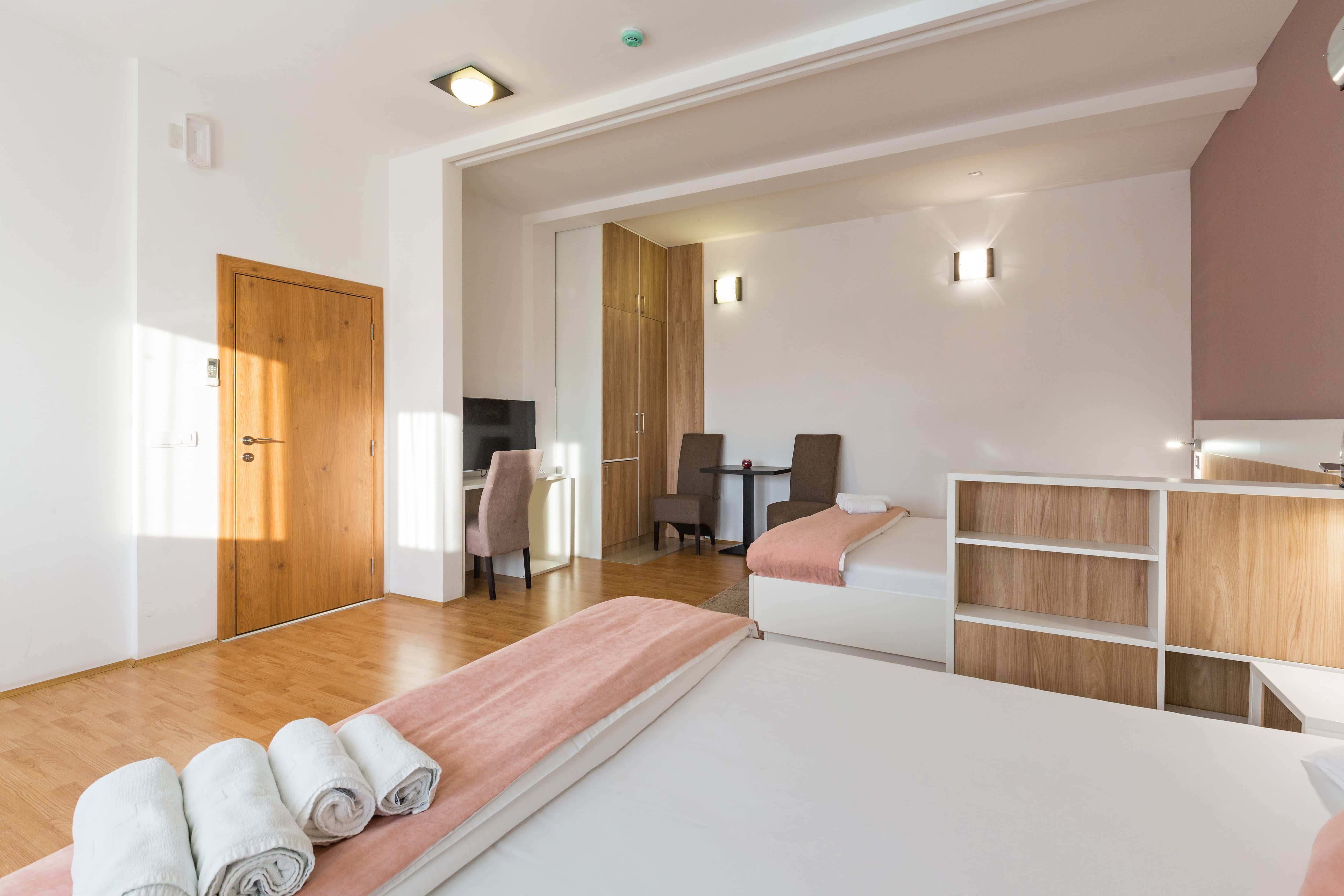 Two beds in room divided by pony wall