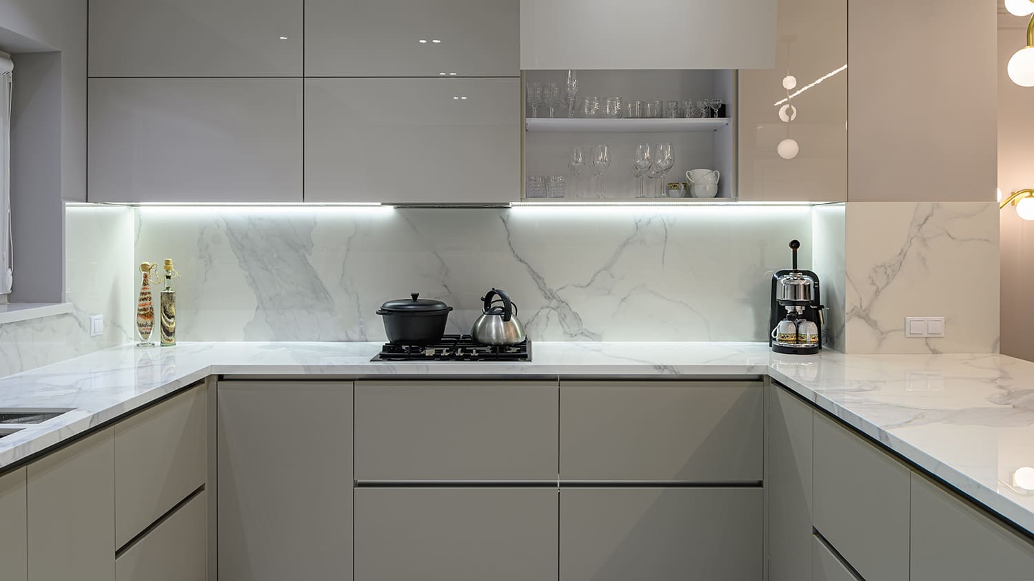 Halogen lights under grey modern kitchen cabinets