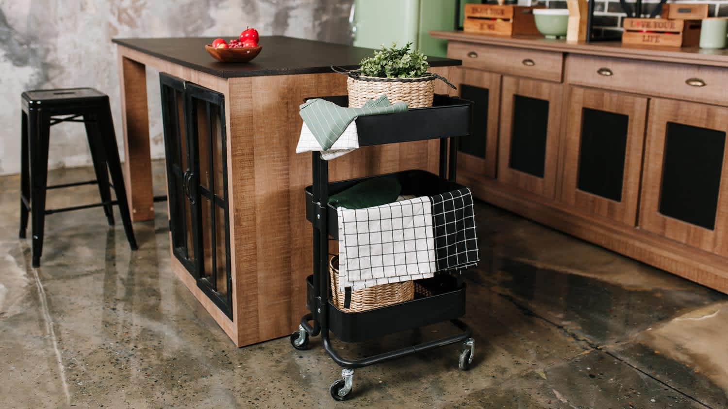 A kitchen island and a cart with wooden cabinets