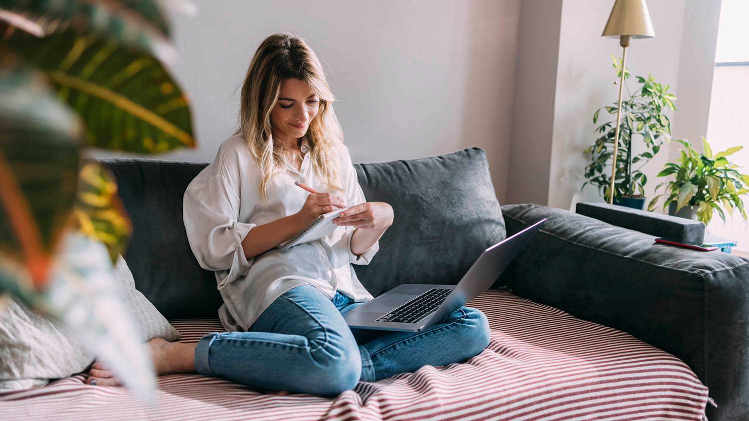 woman looking at phone while sitting on couch