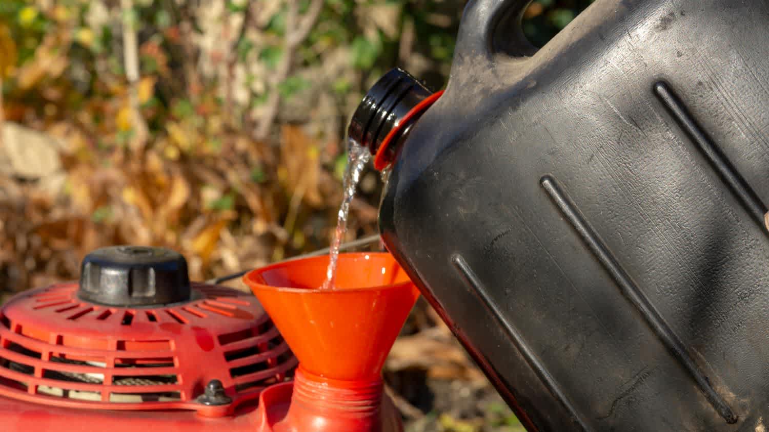 Pouring gas in a lawn mower