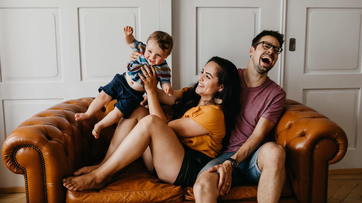 Father and mother with son on sofa at home