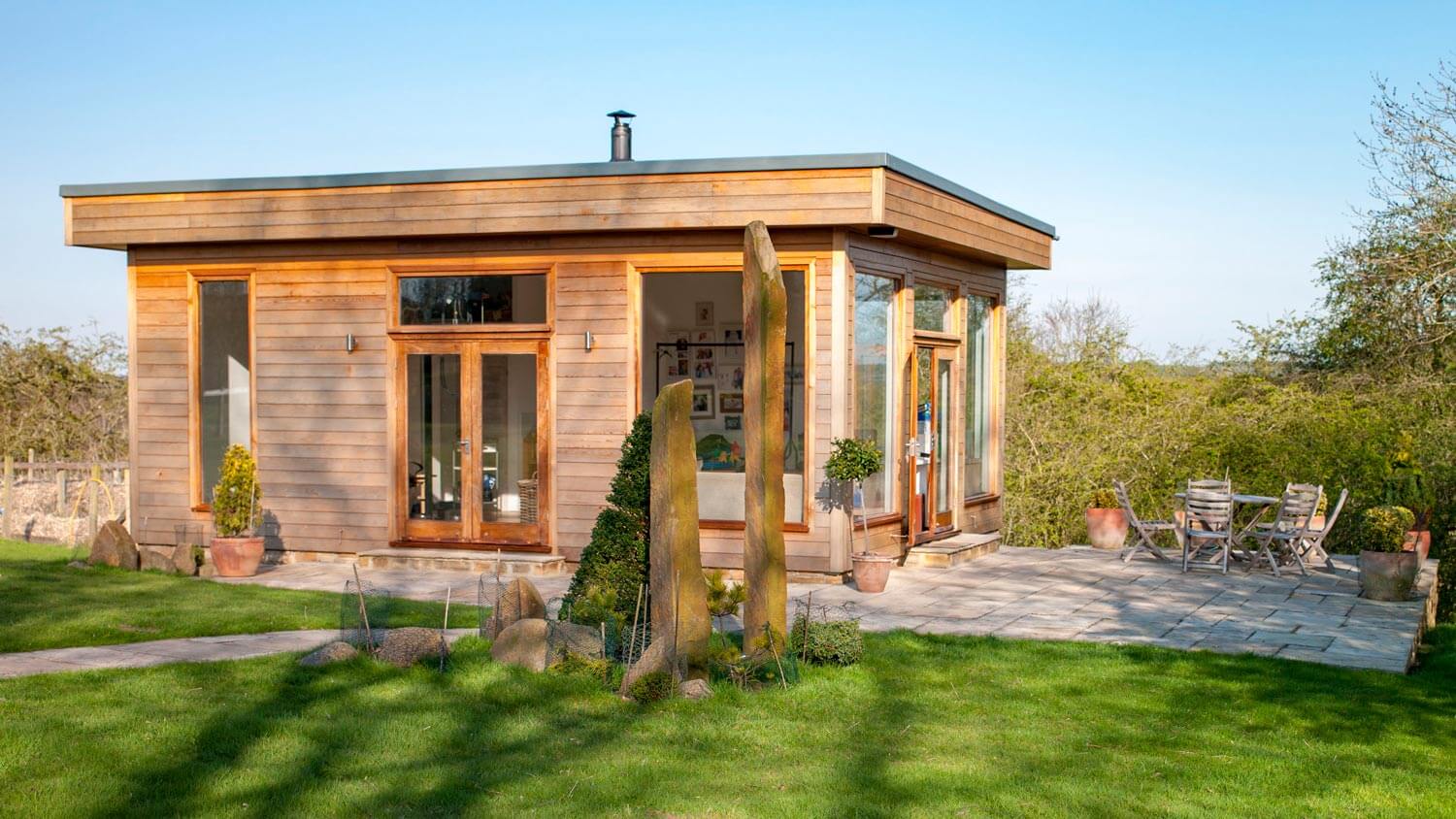 A wooden house with a beautiful garden and lawn