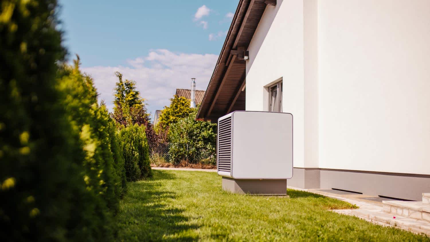 Heat pump standing in backyard during summer