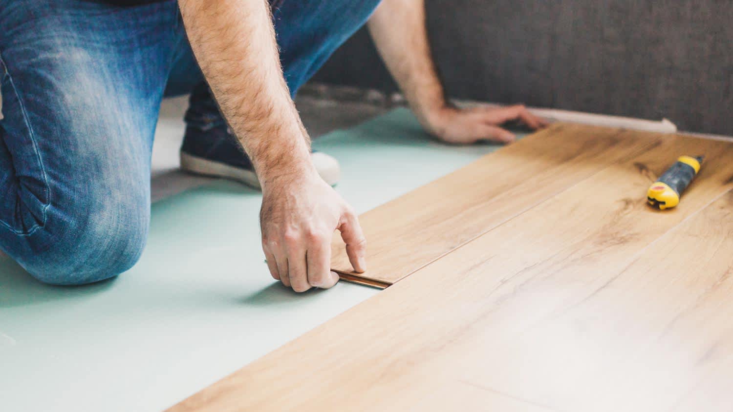 A worker installing bamboo flooring