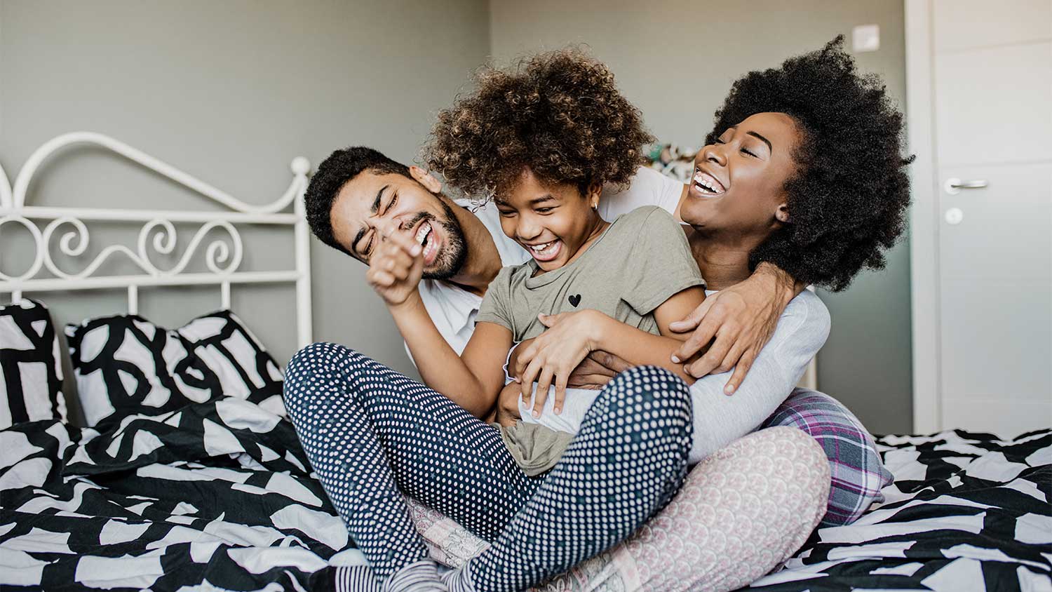 Family playing on bed