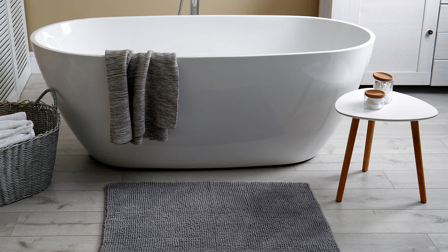 grey microfiber bath mat next to soaking tub